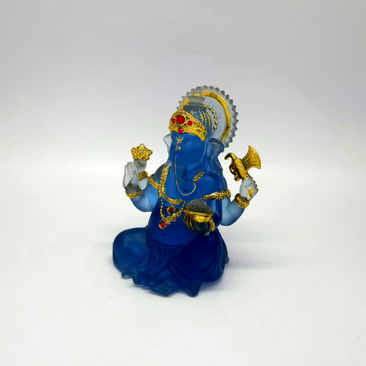 Side angle view showing the glass-like translucent blue resin texture of the Ganesha sculpture.