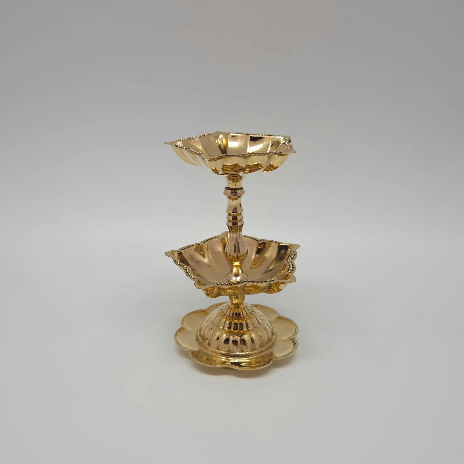 The two-tier brass lamp frame displaying the double oil plate reservoirs.